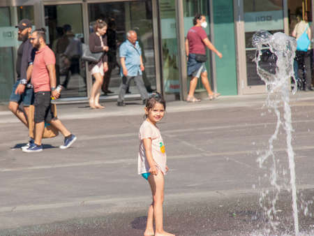 Vienna, Austria - 06.13.2022: Children frolic in the jets of the city fountain in the summer heatのeditorial素材