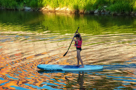 Nitra, Slovakia - 06.15.2022: A young girl is sailing in a canoe on the Nitra river.のeditorial素材