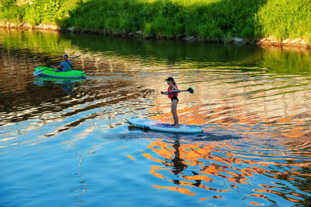 Nitra, Slovakia - 06.15.2022: A young girl and a middle-aged man are sailing in different canoes on the Nitra river.のeditorial素材