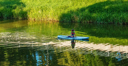 Nitra, Slovakia - 06.15.2022: A teenage boy is sailing in a canoe on the Nitra river.のeditorial素材