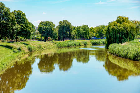 The river flows through the city. On the calm surface of the river ...