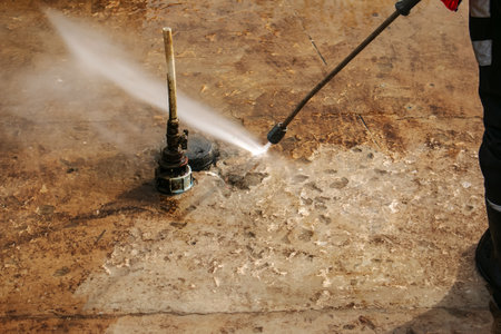 A man uses an electric pressure washer for a pressure washer. Cleaning city fountains in autumn. Workers remove the dirt that has settled during the season.の写真素材