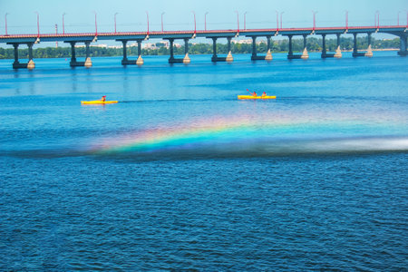Athletes in kayaks in training near the river fountain in a rainbow of splashes.の写真素材
