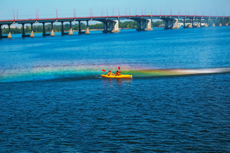 Dnepropetrovsk, Ukraine - 09.11.2021: Athletes in kayaks in training near the river fountain in a rainbow of splashes.の写真素材