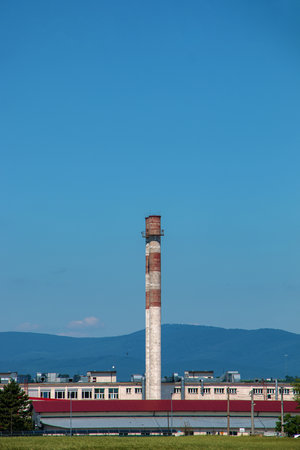 View en pipe exhaust of an industrial plant against the blue sky. The company is not working. There...