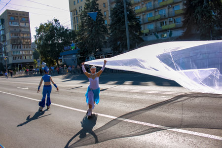 Dnipro, Ukraine - 09.11.2021: Citizens celebrate City Day. Rollerblading dancers waving the flag.のeditorial素材