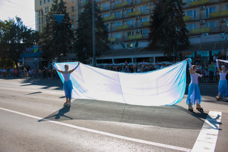 Dnipro, Ukraine - 09.11.2021: Citizens celebrate City Day. Rollerblading dancers waving the flag.のeditorial素材