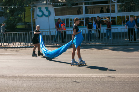 Dnipro, Ukraine - 09.11.2021: Citizens celebrate City Day. Rollerblading dancers waving the flag.のeditorial素材