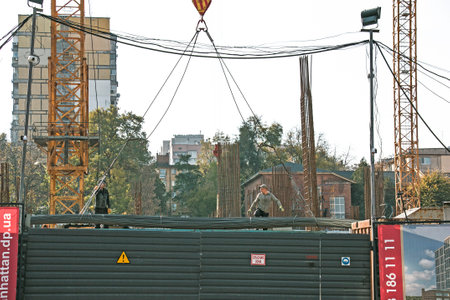 Dnipro, Ukraine - 10.22.2022: Unloading reinforcement for concrete work by a crane from a truck. Residential building constructionのeditorial素材