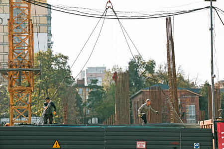 Dnipro, Ukraine - 10.22.2022: Unloading reinforcement for concrete work by a crane from a truck. Residential building constructionのeditorial素材