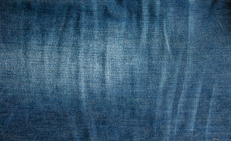Blue denim background. Texture of classic frayed jeans