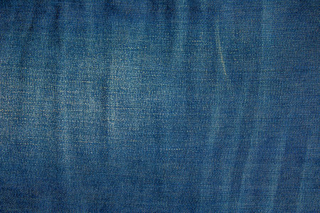 Blue denim background. Texture of classic frayed jeansの写真素材