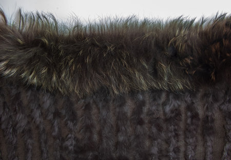 Background from dark brown fur and wool. Combined knitted fur product with inserts of fox wool and...