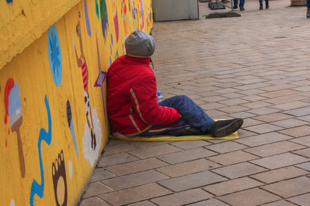 Bratislava, Slovakia - 07/01/2023: Homeless poor man sits on the pavement on the city street.のeditorial素材