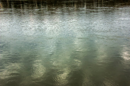 Background of the surface of the Danube river in a winter sunny day. Reflection of sun glare on the water surface with characteristic ripples.の写真素材