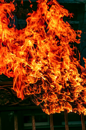Bright fire on the fence. Clubs of orange fire burn everything. fire. Burning flame as a background.の写真素材
