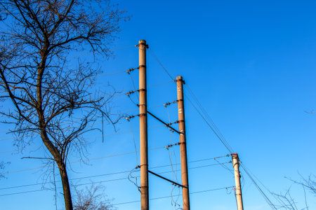 Electric pole with a linear wire against the blue sky close-up. Power electric field.の写真素材