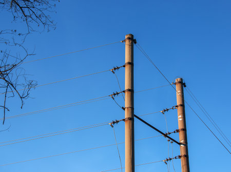 Electric pole with a linear wire against the blue sky close-up. Power electric field.の写真素材