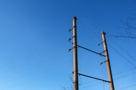 Electric pole with a linear wire against the blue sky close-up. Power electric field.の写真素材