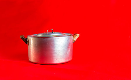 An old aluminum pan made in circa 1960 against a red background.の写真素材