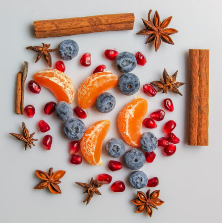 Set of seasonal fruits and spices for winter drinks and food. Cinnamon sticks, star anise, pomegranate seeds, mandarin, blueberry. Background of spices for mulled wine.の写真素材