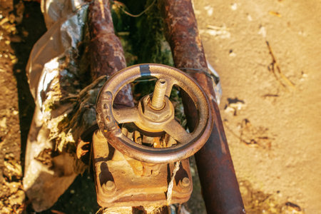 Old rusty faucet for hot water supply and water supply pipes. Thermal insulation broken.の写真素材