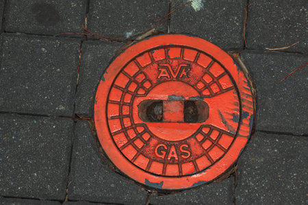 Manhole cover of the gas pipeline system. A massive metal hatch for access to city communications in the pavement.の写真素材