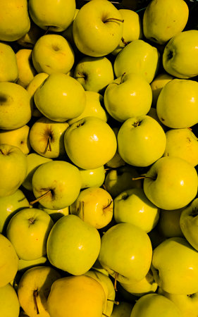 Background of ripe fresh yellow apples at the food market. top view.の写真素材