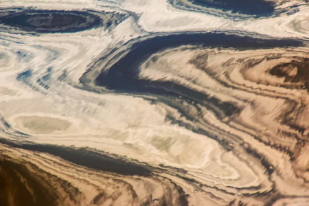 Water ripple texture background. Wavy water surface during sunset, golden light reflecting in the water.の写真素材