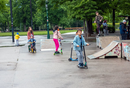 Austria, Vienna - 05.13.2023: Children ride scooters in one of the parks in Vienna.のeditorial素材