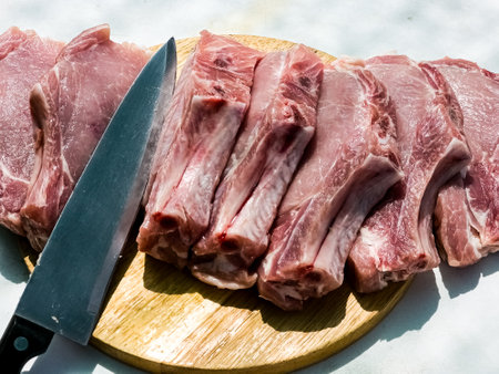 Fresh portioned raw pork ribs steaks on a wooden kitchen board. Pieces of pig meat close-upの写真素材