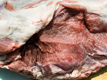 Fresh whole piece of pork neck on a wooden kitchen board. Piece of pig meat close upの写真素材