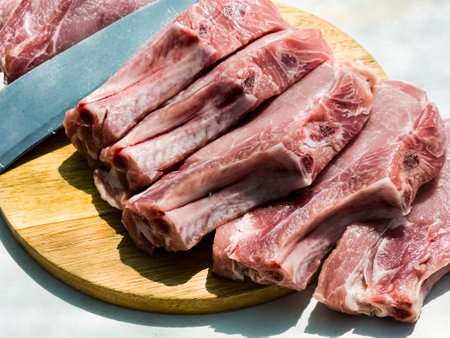 Fresh portioned raw pork ribs steaks on a wooden kitchen board. Pieces of pig meat close-upの写真素材