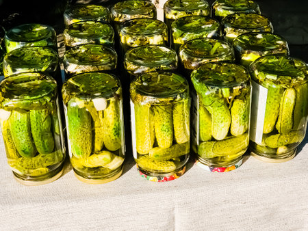 The process of pickling cucumbers for the winter in glass jars. Cucumbers and spices for pickling are laid out in jars. Preservation is ready.の写真素材