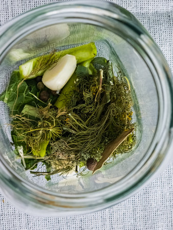 The process of pickling cucumbers for the winter in glass jars. Spices for salting are laid out in jars.の写真素材