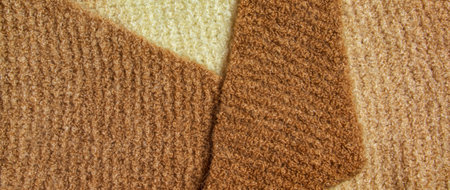 Knitted wool textile with background texture in light beige creamy brown shade. Beige color gradient on texture background. scarf.の写真素材