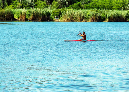 Dnipro, Ukraine - 06.20.2023: Technique of rowing of a single athlete on a kayak. Paddle splash motion.のeditorial素材