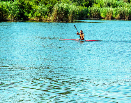 Dnipro, Ukraine - 06.20.2023: Technique of rowing of a single athlete on a kayak. Paddle splash motion.のeditorial素材