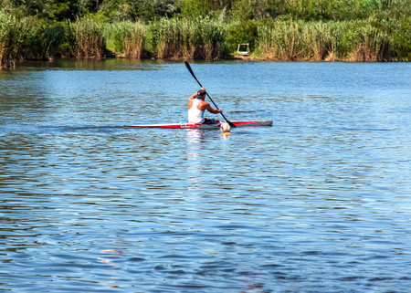 Dnipro, Ukraine - 06.20.2023: Technique of rowing of a single athlete on a kayak. Paddle splash motion.のeditorial素材