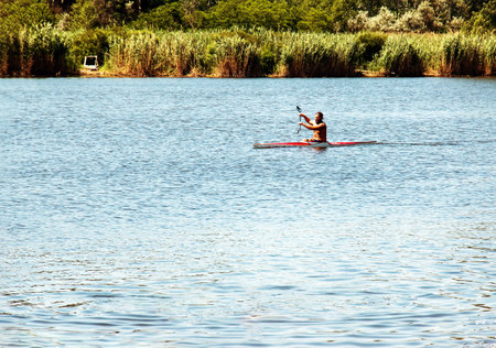 Dnipro, Ukraine - 06.20.2023: Technique of rowing of a single athlete on a kayak. Paddle splash motion.のeditorial素材