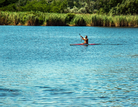 Dnipro, Ukraine - 06.20.2023: Technique of rowing of a single athlete on a kayak. Paddle splash motion.のeditorial素材