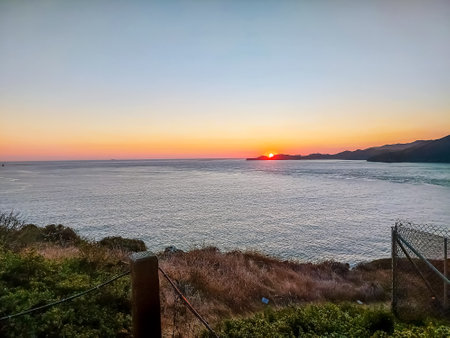 The setting sun over the bay in the Pacific Ocean in San Francisco.の写真素材
