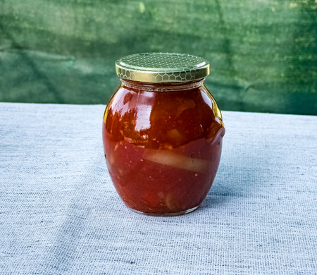 Traditional Hungarian homemade lecho in glass jars. Preserved tomatoes and peppers with spices.の写真素材