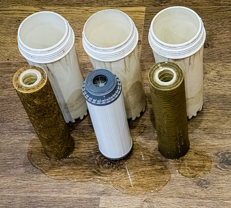 Three used water filters with traces of dirt, clay and contaminants. Replacing multi-stage water filter cartridges.の写真素材