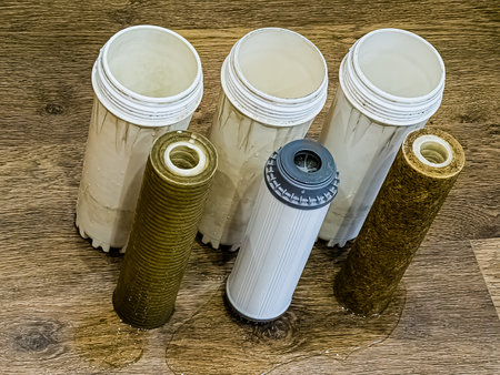 Three used water filters with traces of dirt, clay and contaminants. Replacing multi-stage water filter cartridges.の写真素材