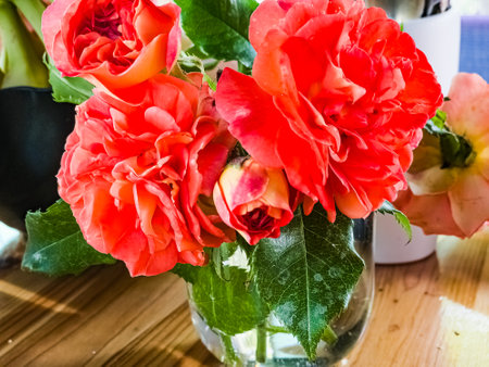 A bouquet of red roses in a glass on the table. Bouquet of roses in a rustic style.の写真素材
