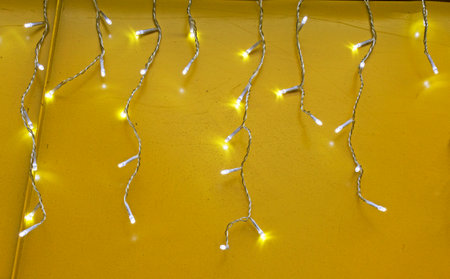 The garland is on fire. Glowing electric garland on a yellow background.の写真素材