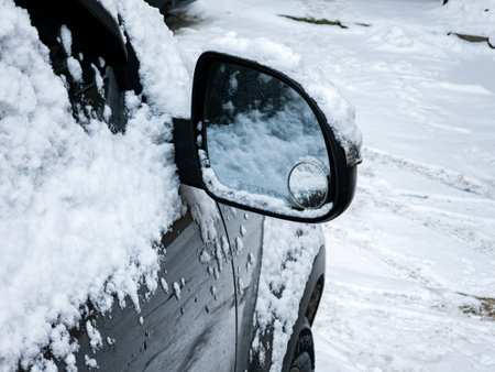 Close-up of a side mirror of a modern car covered in snowの写真素材