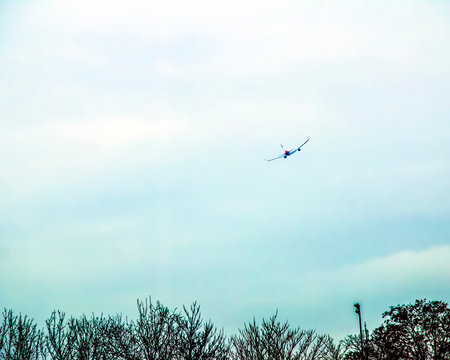 A plane lands at Vienna Airport against a cloudy sky.の写真素材