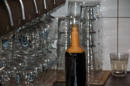 Behind the counter. Women's hands beautifully and easily pour beer into a bottle.の写真素材